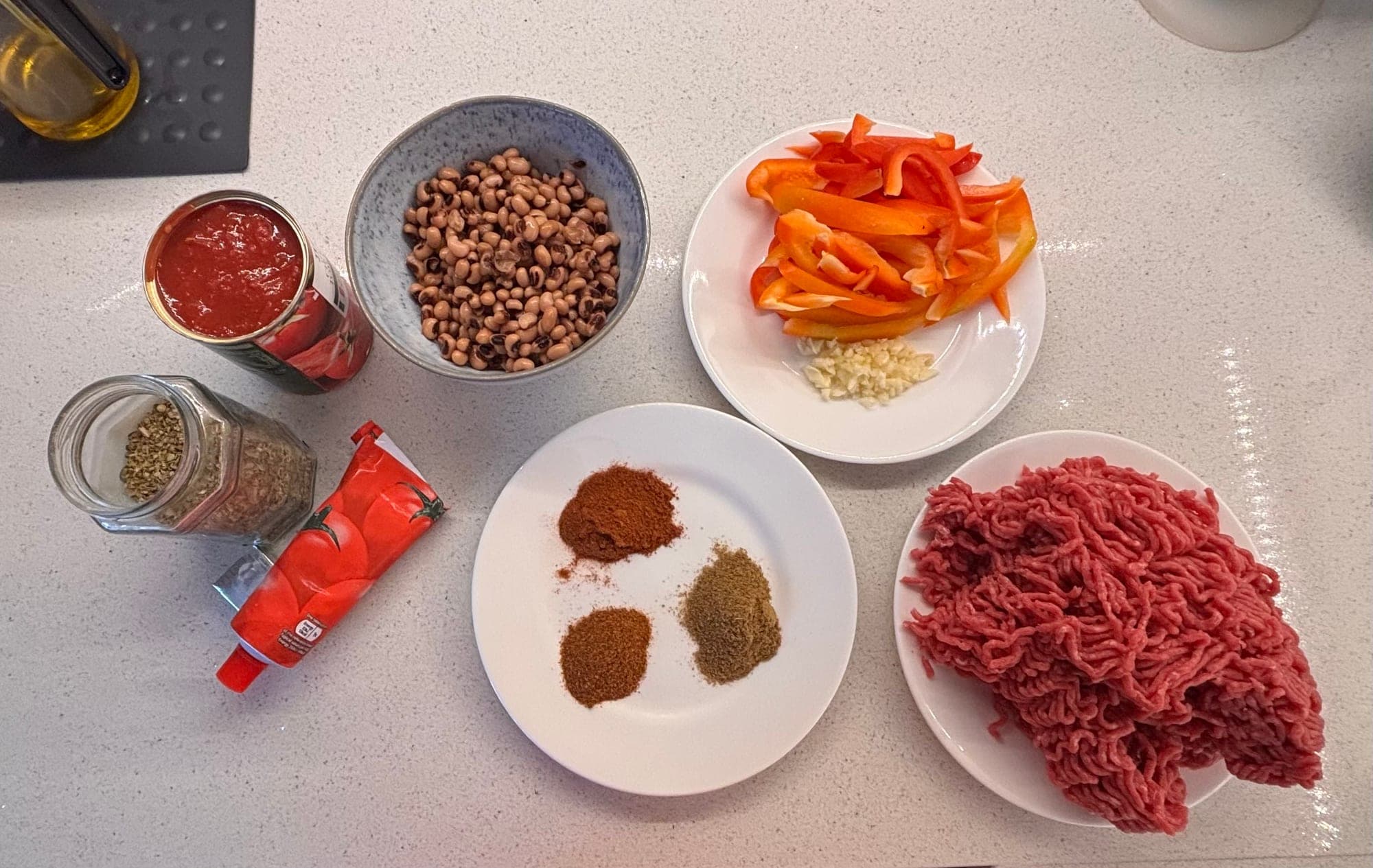 Chilli con carne ingredients on a worktop: mince, peppers, garlic, spices, tomatoes and beans, Cooking It Bristol